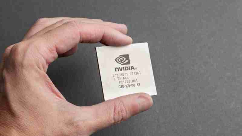 A close-up view of a person holding an Nvidia chip with a gray background. - A close-up view of a person holding an Nvidia chip with a gray background., tags: auf - pexel